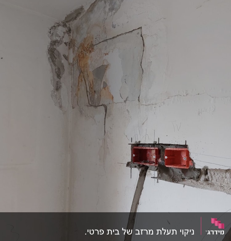 קיר עם סדקים ותיקוני טיח ליד התקרה